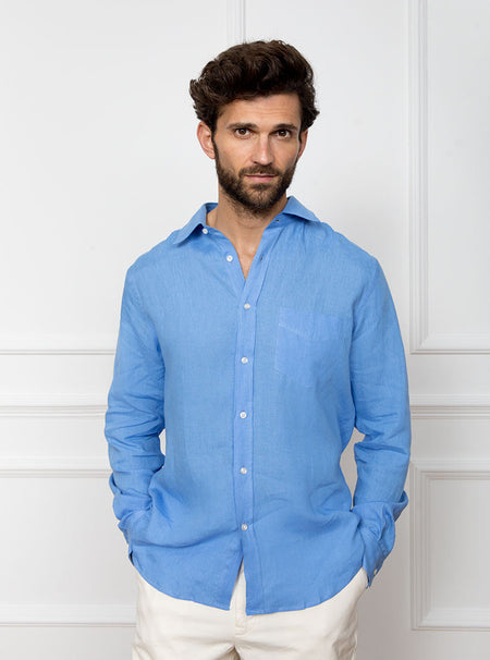 Man wearing a sky blue long sleeved shirt with pocket detail made with 100% linen in a Thomas Mason fabric.
